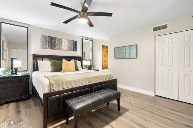 a bedroom with a bed a mirror and furniture