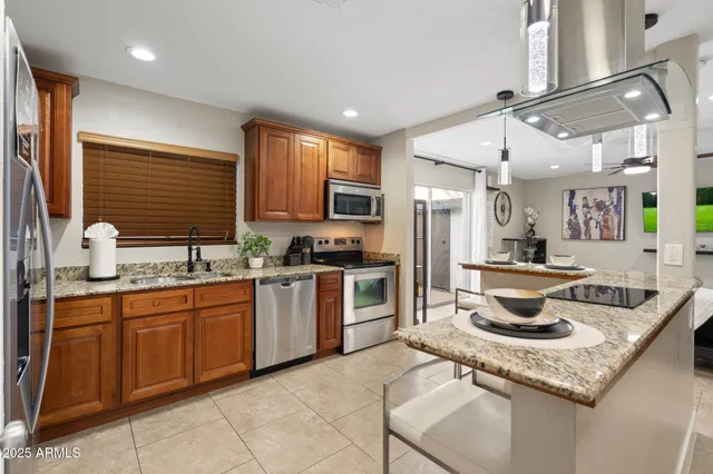 a kitchen with stainless steel appliances granite countertop a sink stove and refrigerator