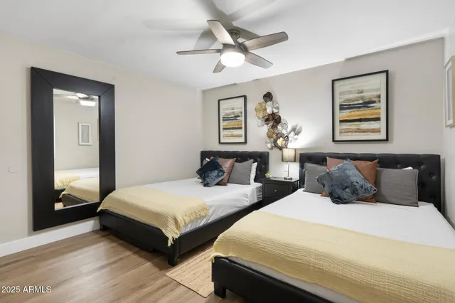 a bedroom with two beds and a large mirror