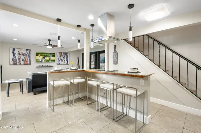 a living room with furniture a large window and kitchen view