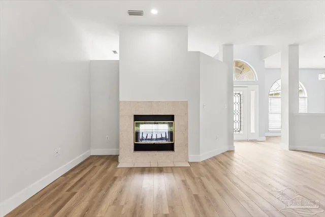 a living room with furniture a wooden floor and a fireplace