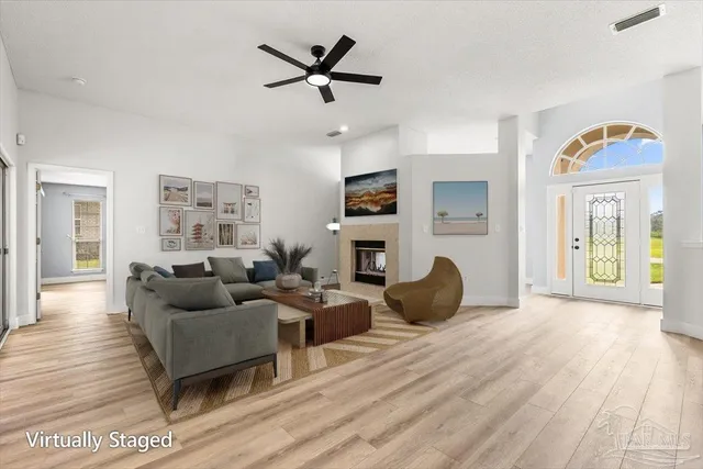 a view of a livingroom with wooden floor and a ceiling fan