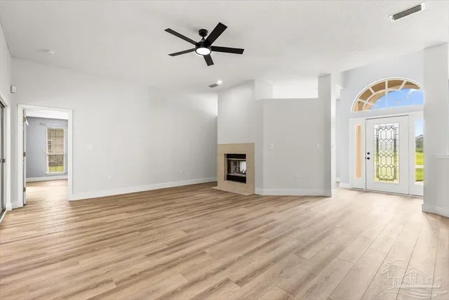 a view of a room with wooden floor and a ceiling fan