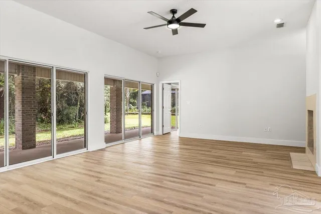 a view of empty room with wooden floor and window