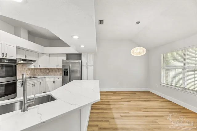 a large kitchen with a refrigerator and a stove top oven
