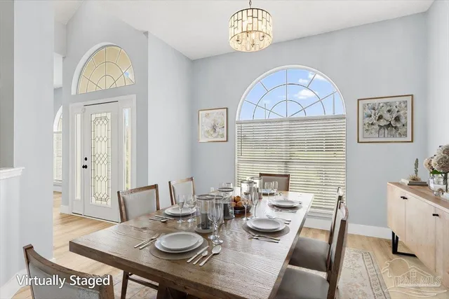 a view of a dining room with furniture a chandelier and wooden floor