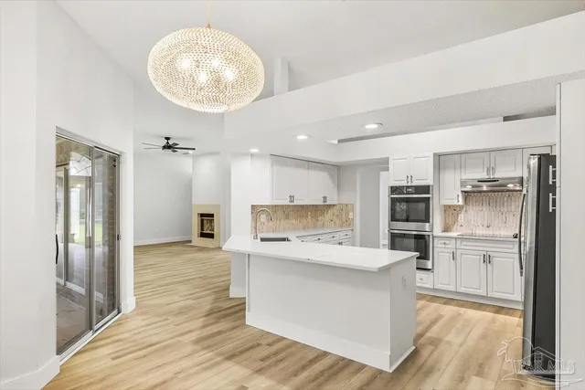 a kitchen with white cabinets and appliances