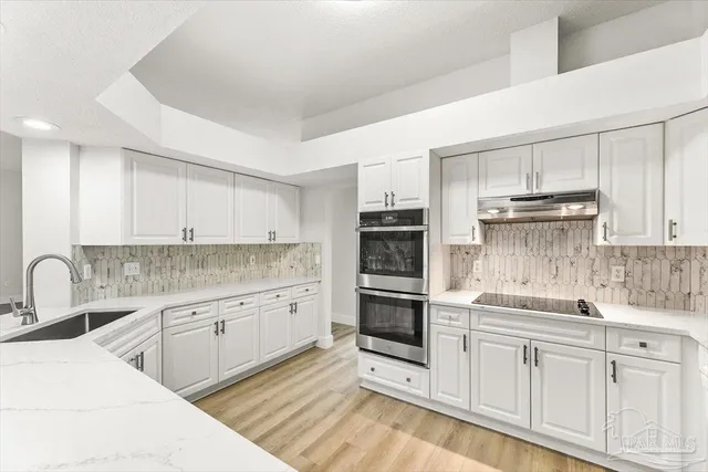 a kitchen with a refrigerator sink and cabinets