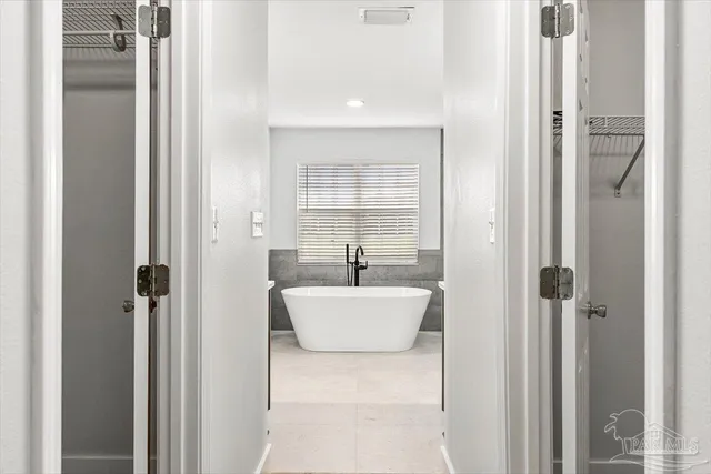 a spacious bathroom with a double vanity sink a mirror and a shower