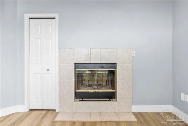 a view of empty room with wooden floor and fireplace