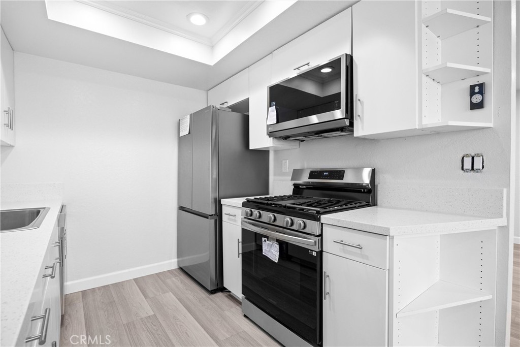 114 10th Street, Unit B Huntington Beach, CA 92648 - Photo 3 of 11 a kitchen with stainless steel appliances a sink a stove and microwave