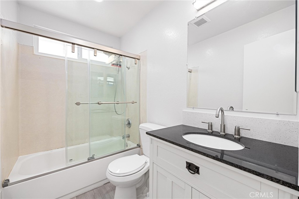 114 10th Street, Unit B Huntington Beach, CA 92648 - Photo 4 of 11 a bathroom with a sink toilet a mirror and shower