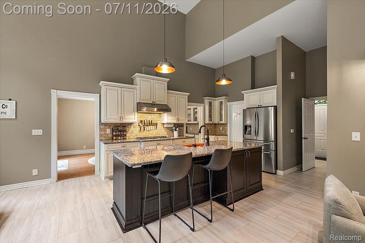 4219 Gardner Road Metamora, MI 48455 - Photo 14 of 87 Kitchen featuring a central island with a stone countertop, off-white cabinetry, and stainless steel appliances