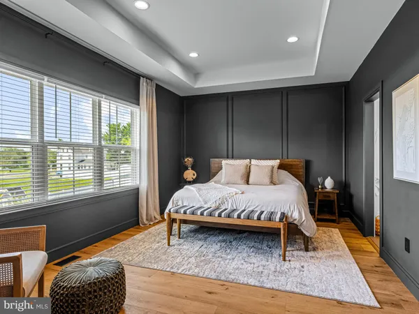 a bed sitting in a spacious bedroom next to a window