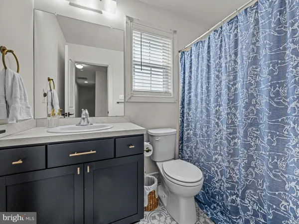 a bathroom with a granite countertop toilet a sink and a mirror