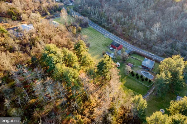 an aerial view of residential houses with outdoor space and trees