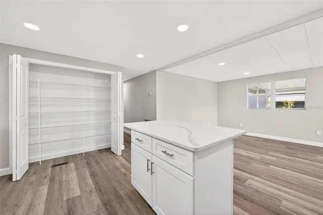 a view of empty room with wooden floor and windows