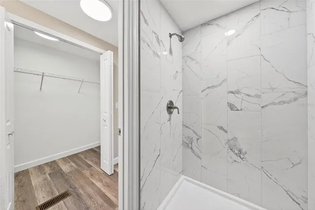 an empty room with wooden floor and ceiling fan