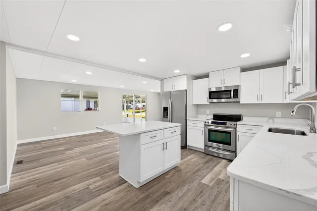 a kitchen with granite countertop white cabinets and white appliances