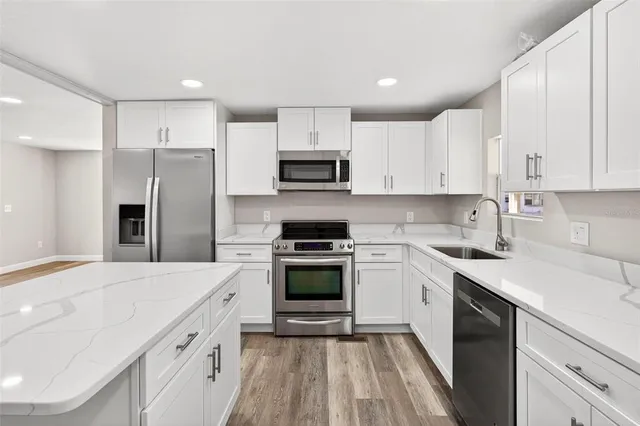 a kitchen with cabinets stainless steel appliances and a counter space