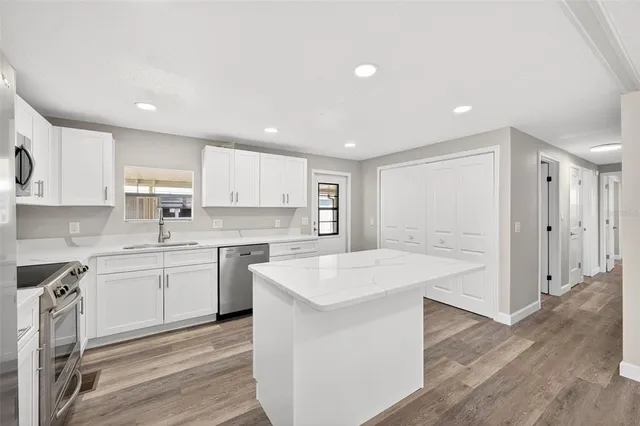 a kitchen with a sink microwave and cabinets