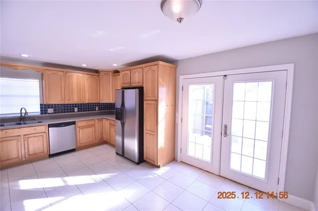 a kitchen with granite countertop white cabinets and stainless steel appliances