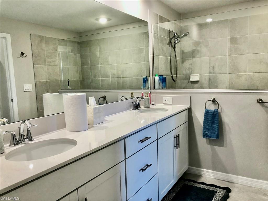 43253 Water Bird Way, Unit 5811 Babcock Ranch, FL 33982 - Photo 13 of 21 a bathroom with a granite countertop sink and a mirror