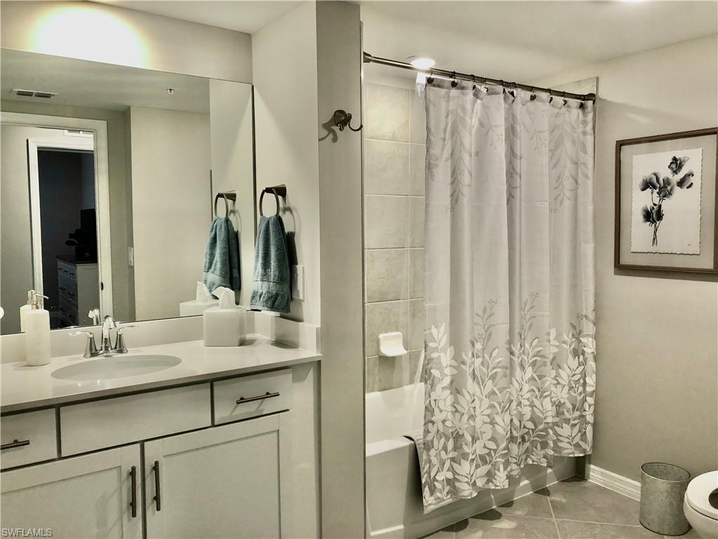 43253 Water Bird Way, Unit 5811 Babcock Ranch, FL 33982 - Photo 17 of 21 a bathroom with a shower curtain a sink and a mirror
