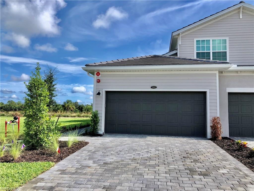 43253 Water Bird Way, Unit 5811 Babcock Ranch, FL 33982 - Photo 2 of 21 a front view of a house with a yard and garage