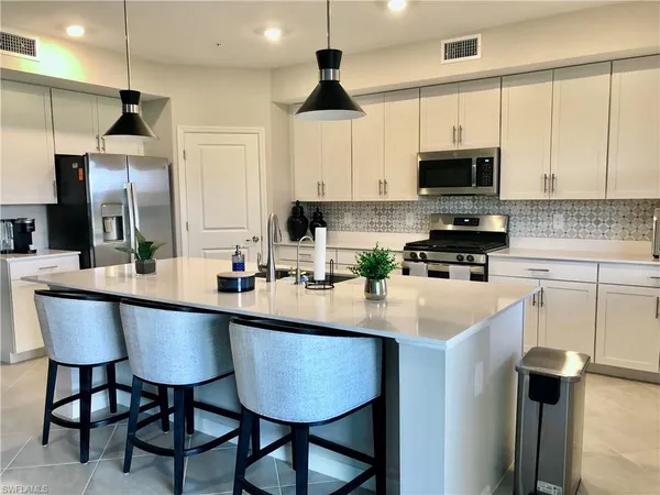 a kitchen with stainless steel appliances a sink a stove a refrigerator and cabinets