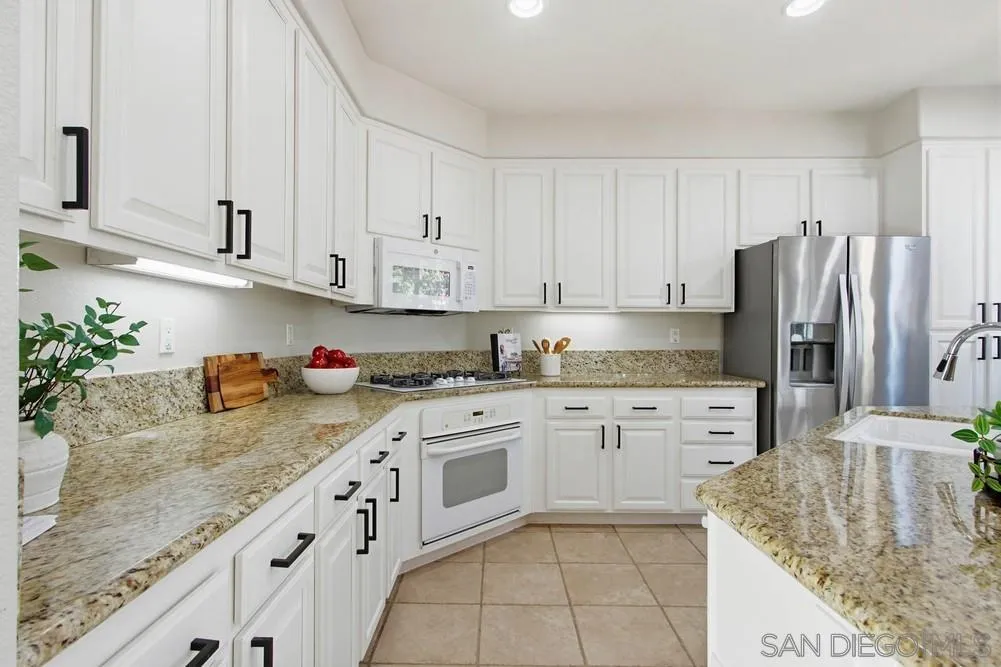 5423 Foxtail Loop Carlsbad, CA 92010 - Photo 13 of 67 a kitchen with granite countertop a sink stove and refrigerator
