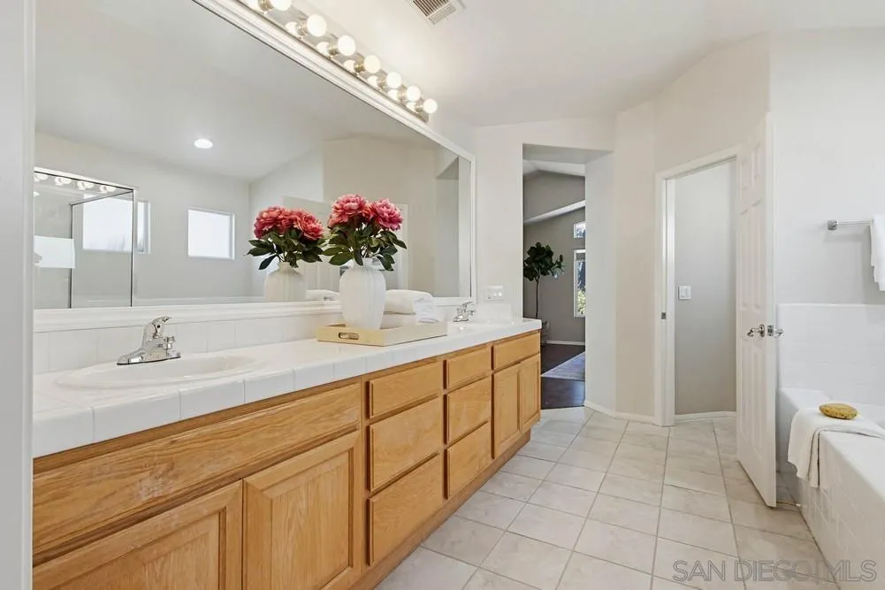 5423 Foxtail Loop Carlsbad, CA 92010 - Photo 33 of 67 a bathroom with a double vanity sink mirror and shower