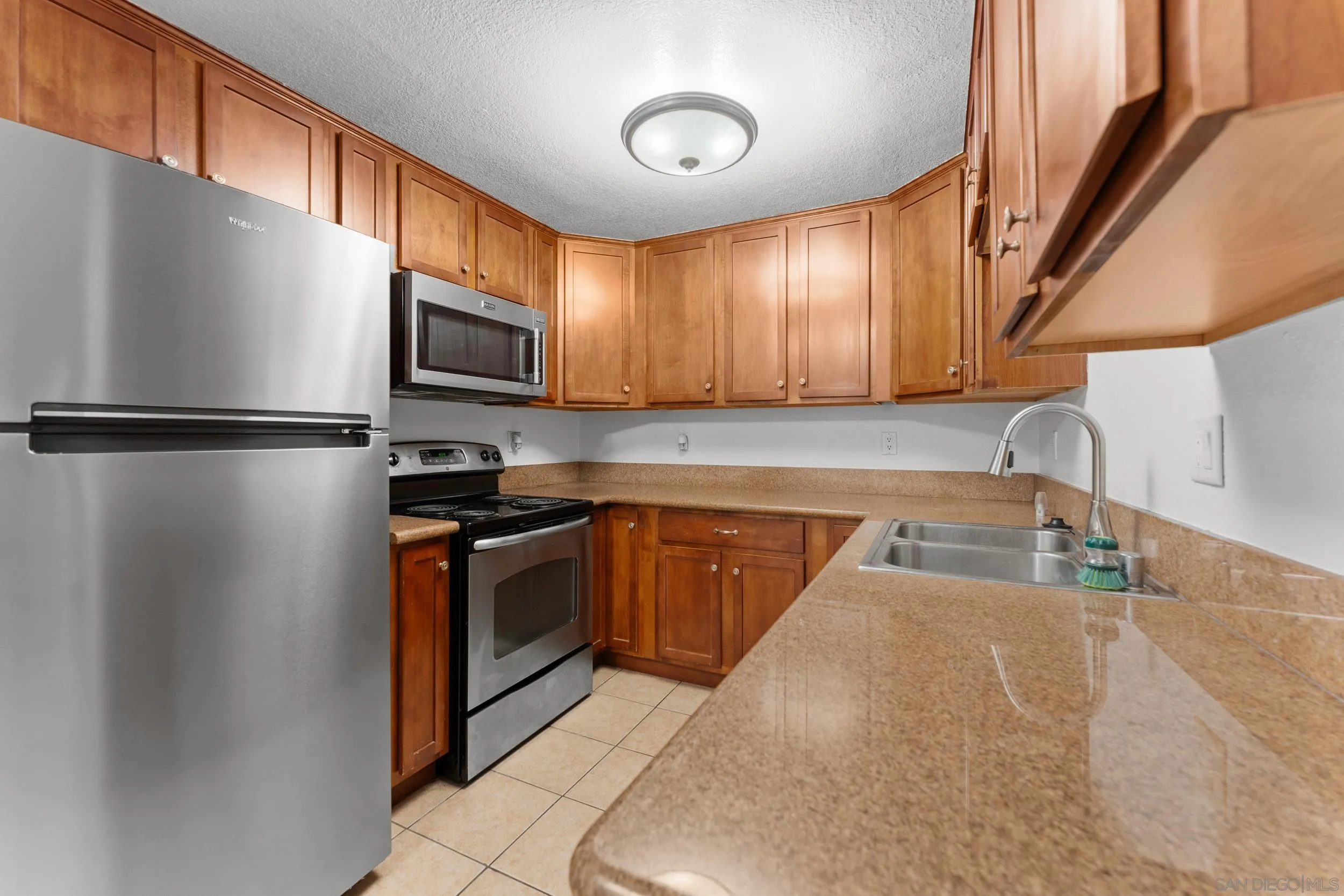 12745 Robison Boulevard Poway, CA 92064 - Photo 11 of 14 a kitchen with stainless steel appliances granite countertop a refrigerator a stove a sink and a microwave