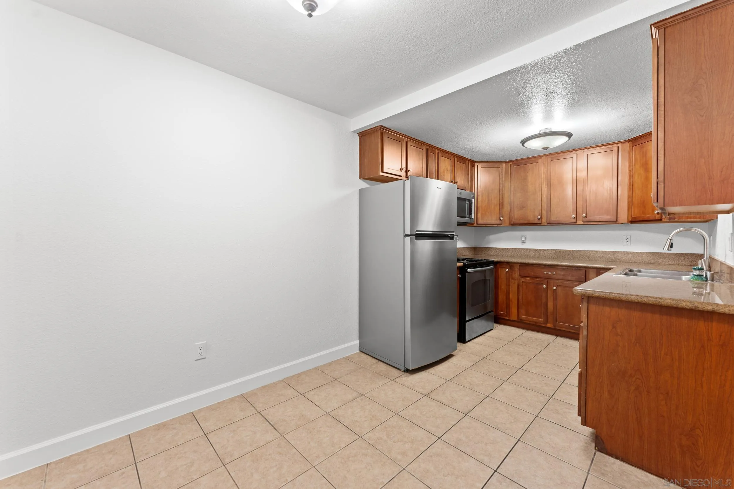 12745 Robison Boulevard Poway, CA 92064 - Photo 9 of 14 a kitchen with a refrigerator sink and cabinets