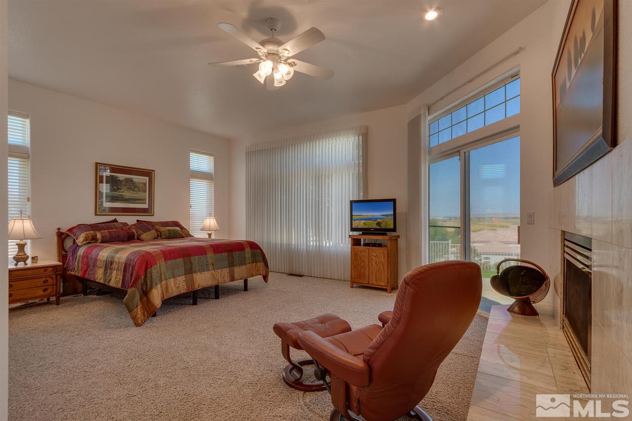 5419 Greenview Court Reno, NV 89502 - Photo 13 of 25 a spacious bedroom with a bed a couch and a chandelier