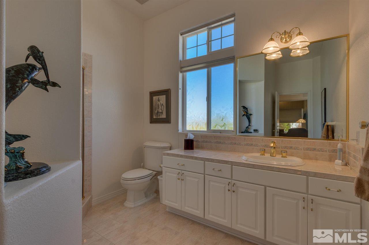 5419 Greenview Court Reno, NV 89502 - Photo 16 of 25 a spacious bathroom with a toilet sink and mirror