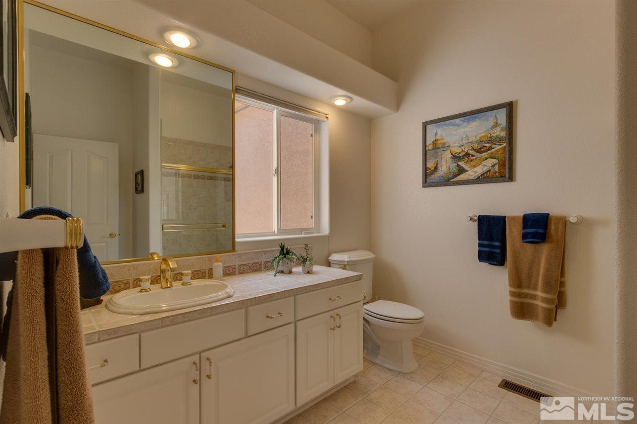 5419 Greenview Court Reno, NV 89502 - Photo 18 of 25 a bathroom with a double vanity sink toilet and a mirror