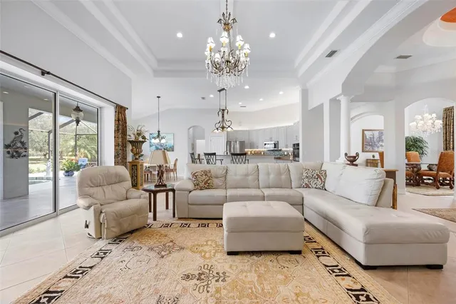 a dining room with furniture a chandelier and wooden floor