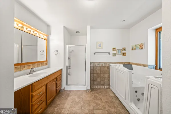 a bathroom with a double vanity sink a mirror and a bathtub