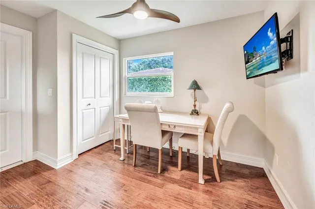 a dining room with furniture a floor to ceiling window and wooden floor