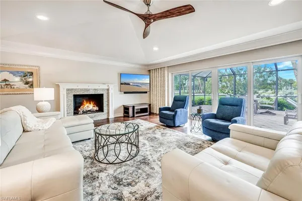 a living room with furniture fireplace and a large window