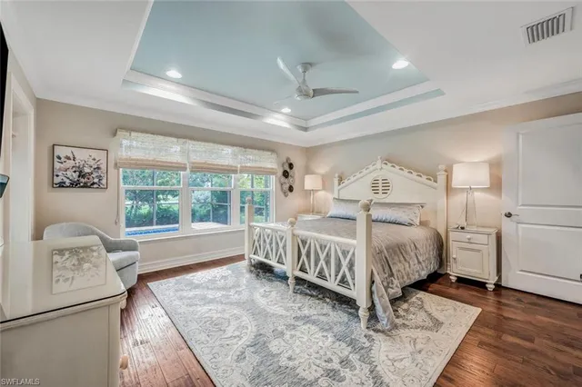 a bed sitting in a spacious bedroom next to a window
