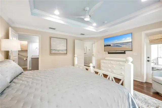 a spacious bedroom with a bed and a flat screen tv