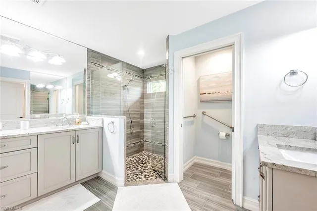 a bathroom with a granite countertop sink mirror and a shower