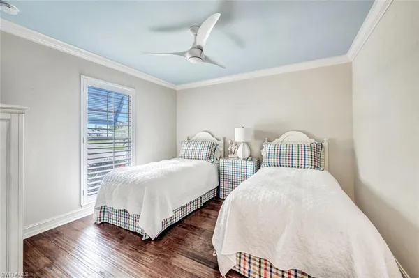 a bedroom with two beds and wooden floor