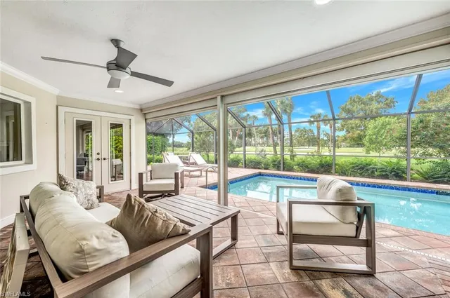 a living room with furniture and a floor to ceiling window
