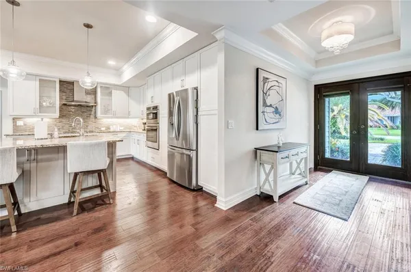 a kitchen with stainless steel appliances a refrigerator a sink dishwasher and a stove with wooden floor