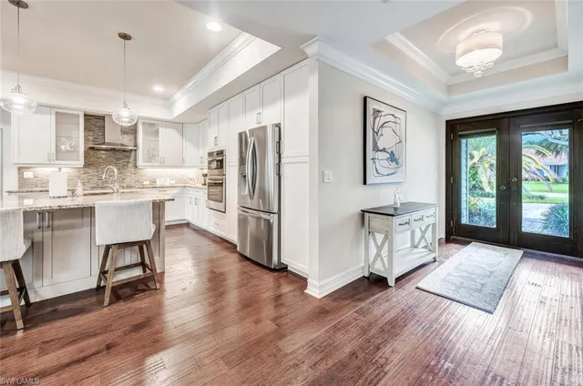 a kitchen with stainless steel appliances a refrigerator a sink dishwasher and a stove with wooden floor