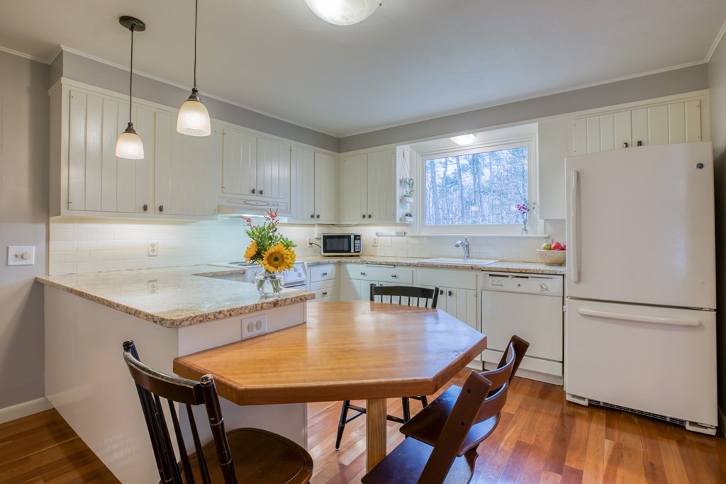 971 Ryan Road Northampton, MA 01062 - Photo 8 of 23 a kitchen with granite countertop a table chairs stainless steel appliances and wooden floor