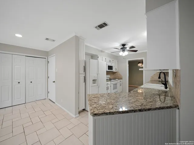 a view of kitchen island a sink wooden floor and chandelier